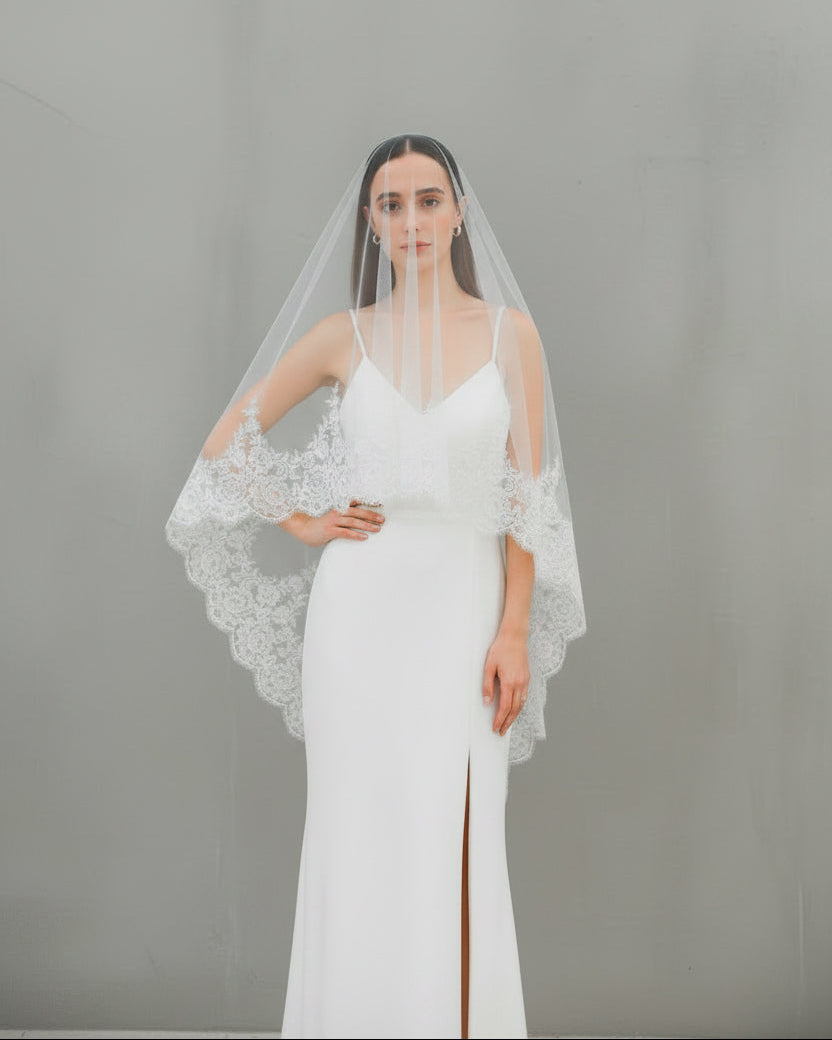 香港婚紗攝影造型：西班牙 Mantilla 風格蕾絲頭紗（Scalloped lace veil）蓋頭戴法，搭配極簡細肩帶婚紗的復古新娘視覺
